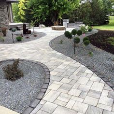 an outdoor patio with stone walkway and landscaping