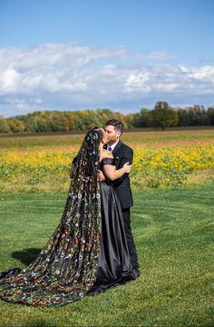 a bride and groom kissing in the middle of a field