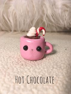 a pink cup filled with hot chocolate and marshmallows on top of it