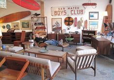 a living room filled with lots of furniture and surfboards