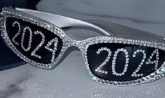 a pair of sunglasses with the numbers 2012 on it and some crystals in front of them