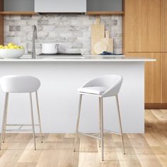 two white stools sitting in front of a kitchen island