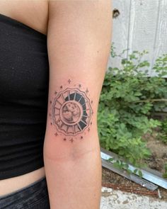 a woman's arm with a tattoo on it that has a clock and stars