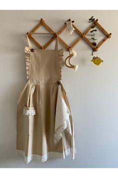 a dress hanging on the wall next to a coat rack with hooks and other items