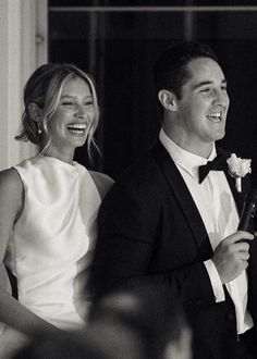 a man in a tuxedo standing next to a woman wearing a white dress