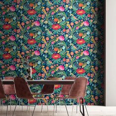 a dining room with colorful wallpaper and chairs