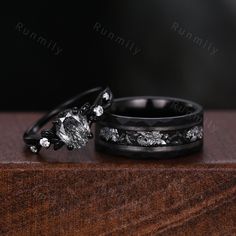 two wedding rings sitting on top of a wooden table next to each other with diamond accents