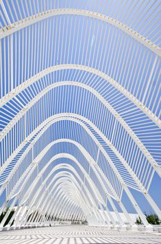 the inside of a white building with blue sky in the backgrouds and lines on the ceiling