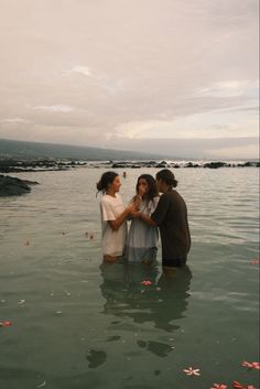 three people standing in the water near each other