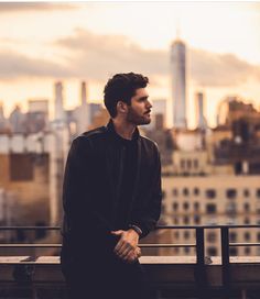 a man standing in front of a city skyline