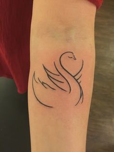 a woman's arm with a black swan tattoo on it