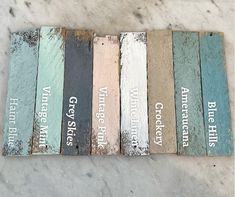 several different colored wood signs sitting on top of a white counter next to each other