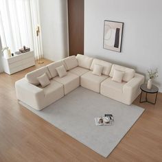 a living room with a large sectional couch and coffee table on the hardwood flooring