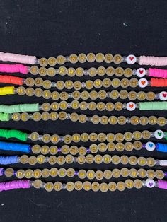 several different colored beads are arranged together on a black surface with the word love spelled in gold