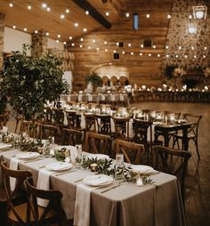 tables set up with place settings and greenery in the center for an elegant wedding reception