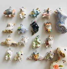 a collection of ceramic animal figurines are displayed on a white surface, including cats and dogs