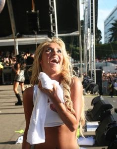 a woman is standing in front of a stage with her towel around her neck and mouth open