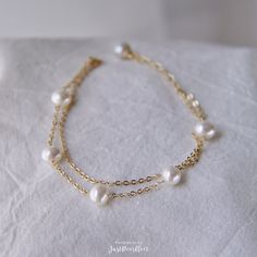 Modern and timeless, this freshwater pearl station bracelet is perfect for a classic looking. Perfectly embodies minimalist aesthetics, this pearl station bracelet makes the perfect addition to any jewelry collection. Handmade in USA. ▷ 5 AA+ quality freshwater pearls with high luster and flawless surface. ▷ 1 half-drilled AA+ quality freshwater pearl with very high luster and smooth surface. ▷ Pearl size: 6.5-7mm. ▷ Adjustable 14K gold plated chain. Chain width: 1.5mm. ▷ 14k gold filled spring خواتم خطوبة, Transitional Outfits, Bridal Bracelet Pearl, Double Chain Bracelet, Pearl Bracelet Wedding, Station Bracelet, White Pearl Bracelet, Layered Bracelet, Artisan Bracelets