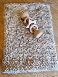 a knitted blanket with wooden buttons on it