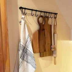 a wooden cutting board sitting on top of a kitchen counter next to a towel rack