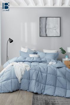 a bed with blue comforter and pillows in a room next to a door that leads to a patio