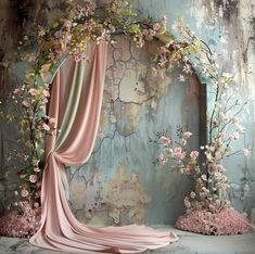 a room with flowers and curtains on the wall, in front of an old door