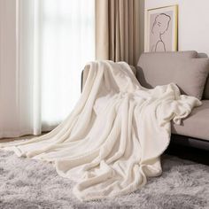 a white blanket is draped over a couch