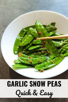 a white bowl filled with green beans and chopsticks