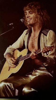 a man that is sitting down with a guitar