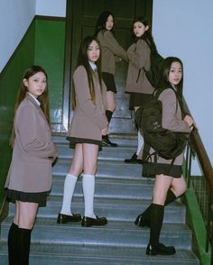 girls in school uniforms are standing on the stairs