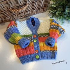 a knitted sweater sitting on top of a table next to a wicker basket