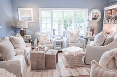 a living room filled with lots of white furniture and pillows on top of it's walls