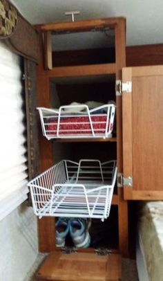 two baskets are sitting on the bottom shelf of a cabinet