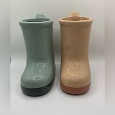 two vases sitting next to each other on a white surface with no one in them