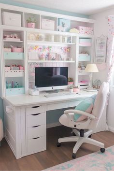 a white desk with a computer on top of it in a room filled with shelves