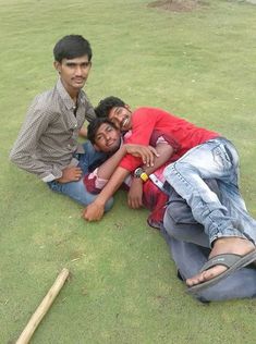 three men are laying on the ground with their arms around each other and one is holding another man