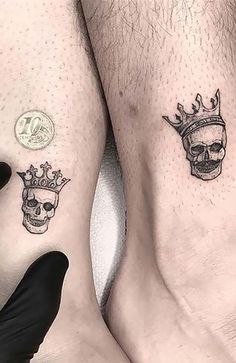 two people with tattoos on their legs and one has a skull wearing a crown tattoo