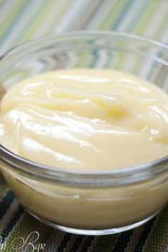 a glass bowl filled with cream sitting on top of a table