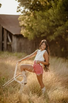 a woman posing with her bike in the grass