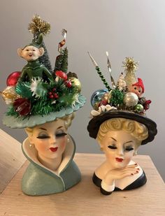 two figurines wearing hats on top of a wooden table