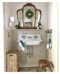 a white sink sitting under a bathroom mirror next to a wooden stool in front of a mirror