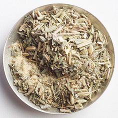 a metal bowl filled with lots of different types of spices and seasoning on top of a white surface