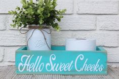 a wooden sign that says hello sweet cheeks on it with some flowers in a mason jar