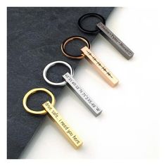 four different types of keychains with names on them sitting on a black surface