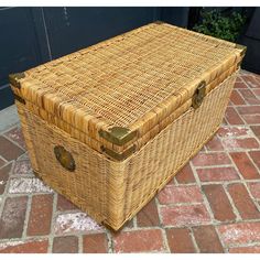 a large wicker trunk sitting on top of a brick floor