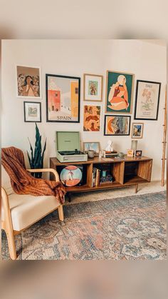 a living room filled with furniture and pictures on the wall next to a carpeted floor