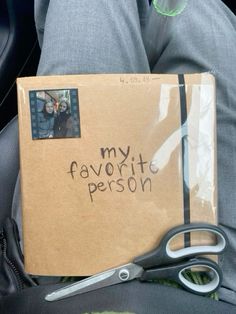 someone is sitting in the back seat of their car holding a box with his favorite person written on it