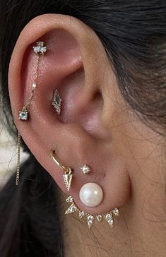 a woman wearing three different ear piercings