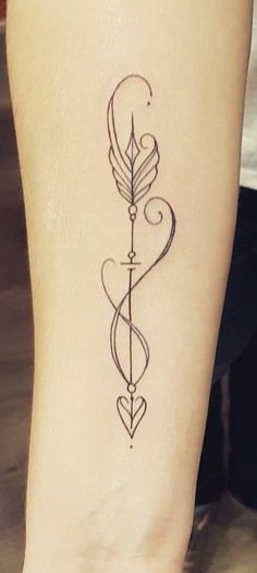 a tattoo on the leg of a woman with an arrow and heart shaped bow in it