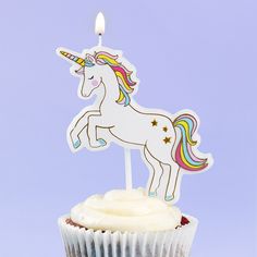 a cupcake with a unicorn candle on top